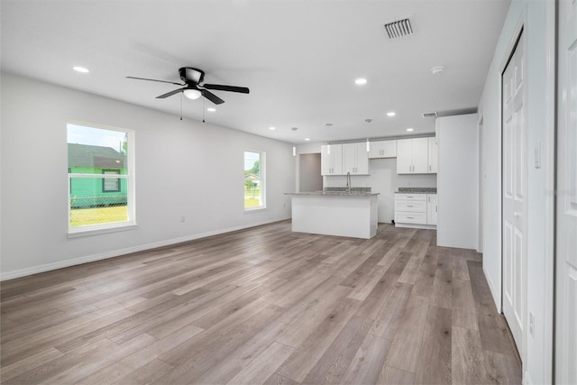 unfurnished living room with light wood-type flooring and ceiling fan