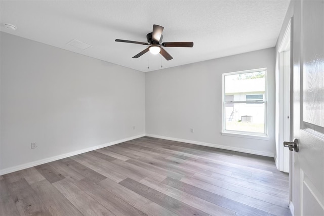 spare room featuring light hardwood / wood-style floors, ceiling fan, and a textured ceiling