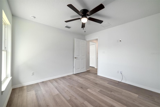 spare room with a textured ceiling, ceiling fan, and light hardwood / wood-style flooring