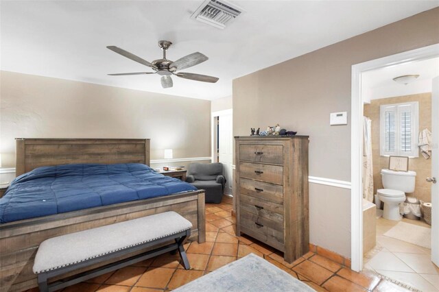 bedroom with ceiling fan, light tile patterned floors, and ensuite bath