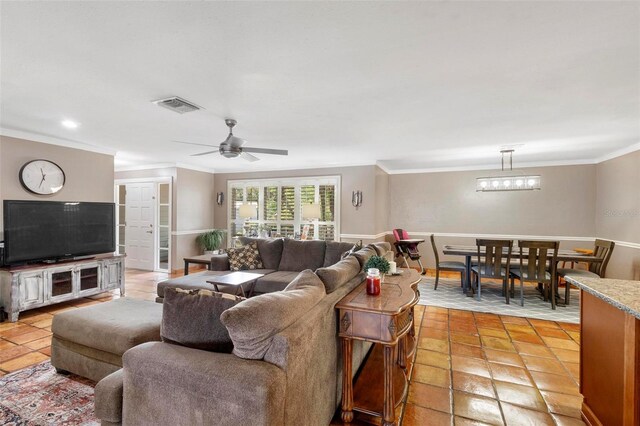 living room featuring light tile patterned floors, ornamental molding, and ceiling fan with notable chandelier