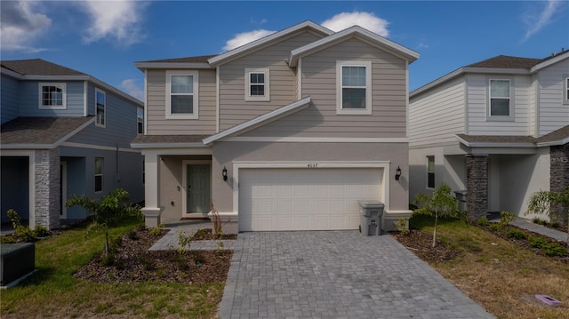 view of front of property featuring decorative driveway, a garage, and stucco siding