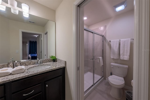 bathroom featuring a shower with door, vanity, tile patterned flooring, and toilet