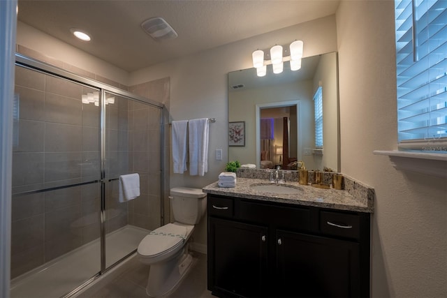 bathroom with walk in shower, tile patterned floors, toilet, and vanity