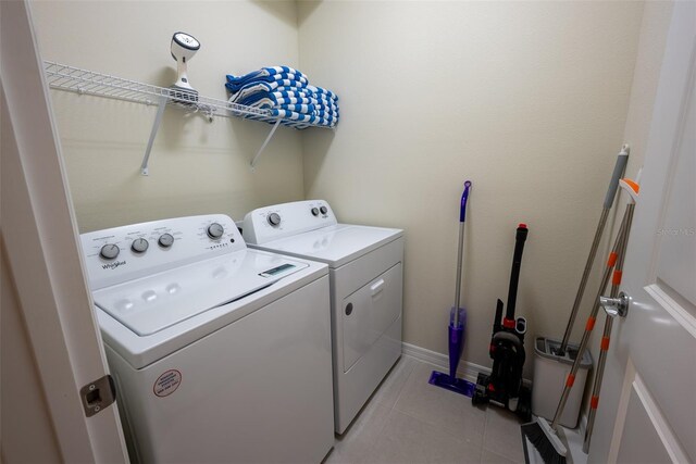 clothes washing area featuring light tile patterned flooring and independent washer and dryer