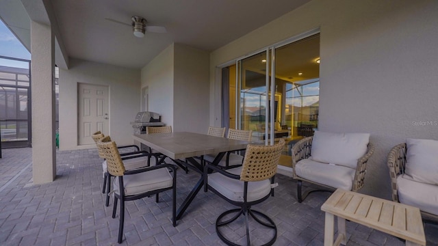 view of patio / terrace featuring a lanai, outdoor dining area, and a ceiling fan