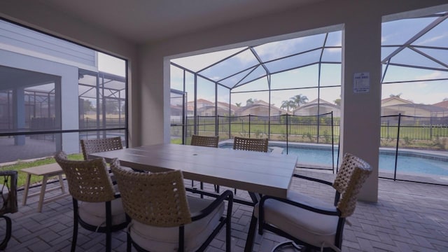 view of patio / terrace featuring glass enclosure, a fenced in pool, and fence