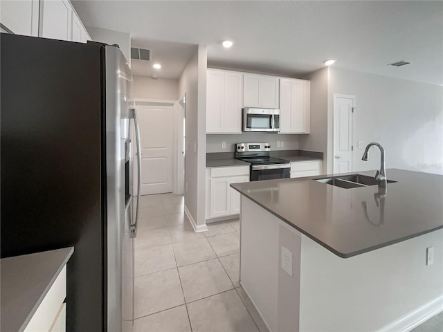 kitchen with light tile patterned floors, appliances with stainless steel finishes, sink, and white cabinets