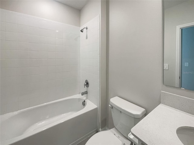 full bathroom featuring tiled shower / bath combo, vanity, and toilet