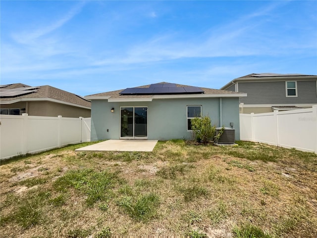 rear view of property with a yard, central AC, a patio, and solar panels