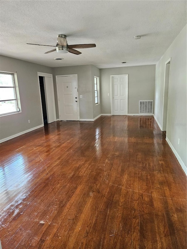 interior space featuring dark wood-type flooring, a textured ceiling, and ceiling fan