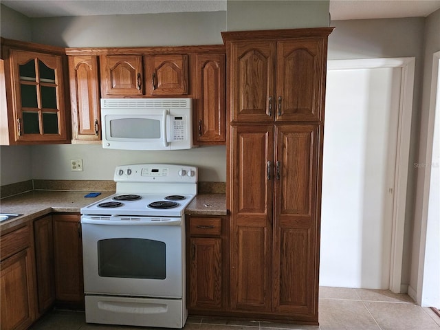 kitchen featuring white appliances and light tile patterned floors