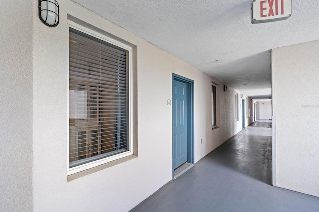 hall featuring a textured ceiling