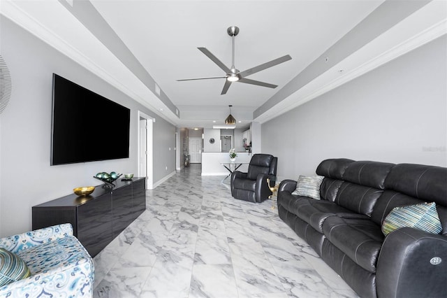 living room with a raised ceiling and ceiling fan