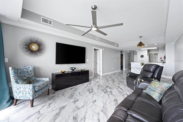 living room featuring a raised ceiling, ceiling fan, and crown molding