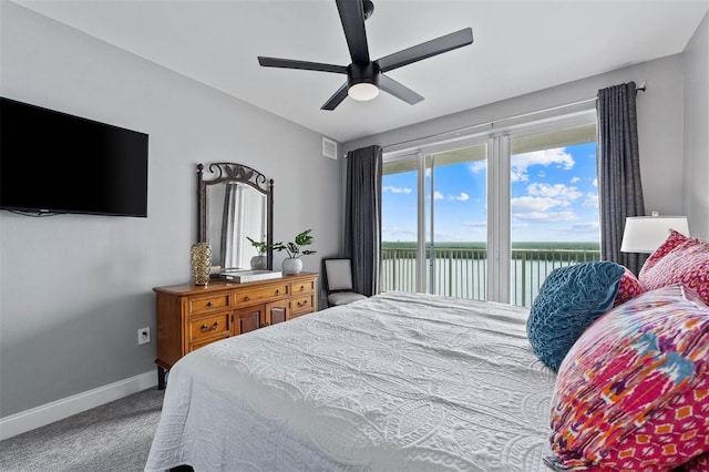 carpeted bedroom with ceiling fan, access to outside, and a water view