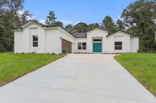 view of front of property featuring a garage and a front lawn