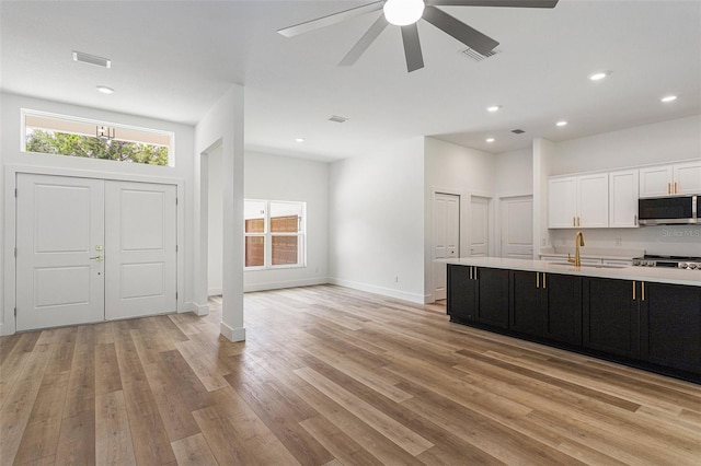 kitchen with sink, ceiling fan, and light wood-type flooring