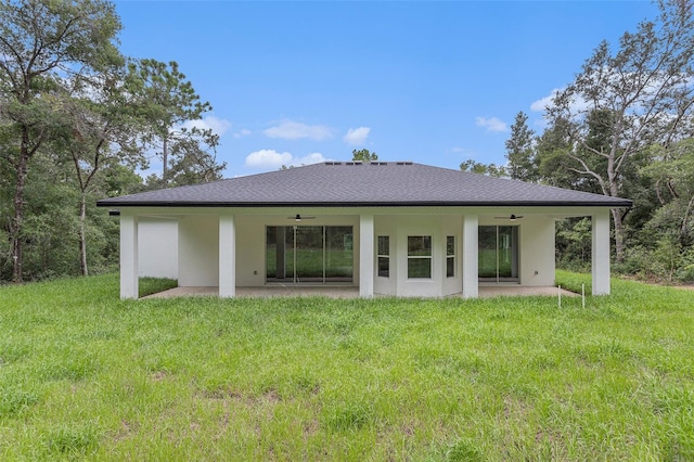 rear view of house with a patio, ceiling fan, and a lawn