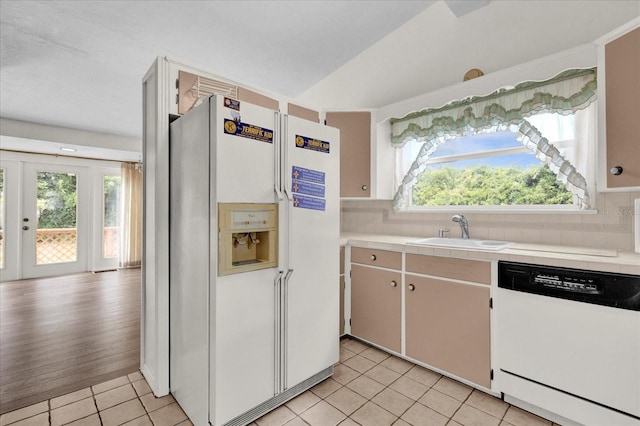 kitchen with french doors, sink, tasteful backsplash, white appliances, and light tile patterned floors