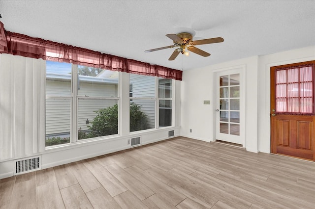 unfurnished sunroom featuring ceiling fan