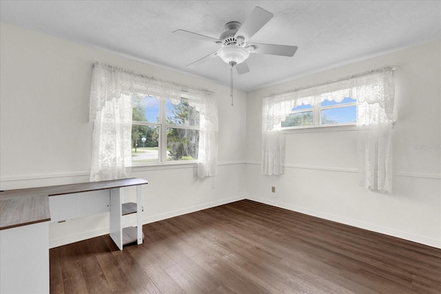 spare room featuring ceiling fan, plenty of natural light, and dark wood-type flooring