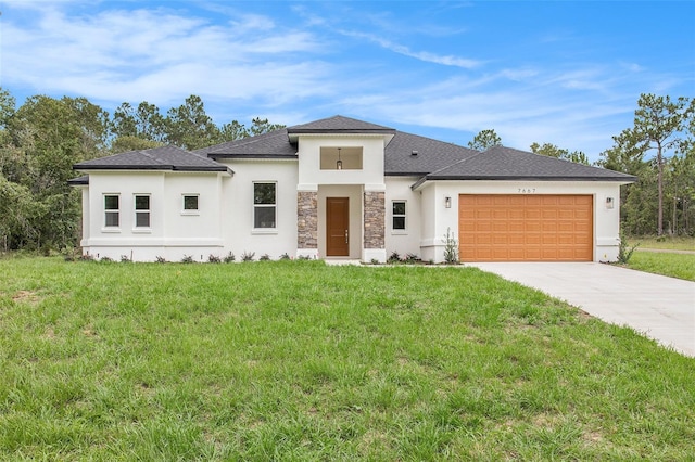 prairie-style house featuring a garage and a front lawn