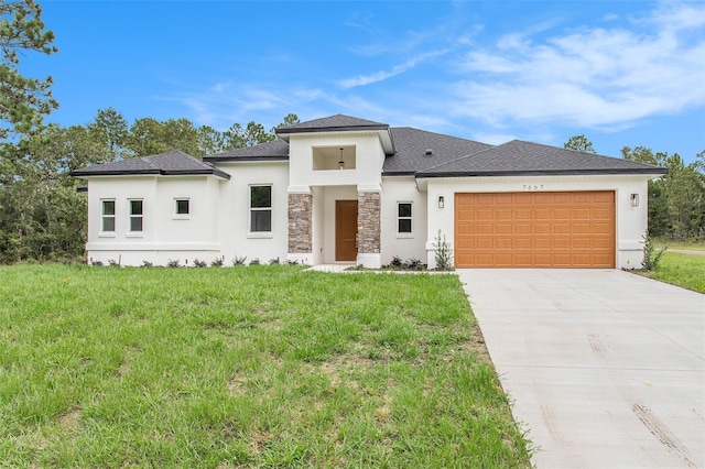 prairie-style house featuring a garage and a front lawn