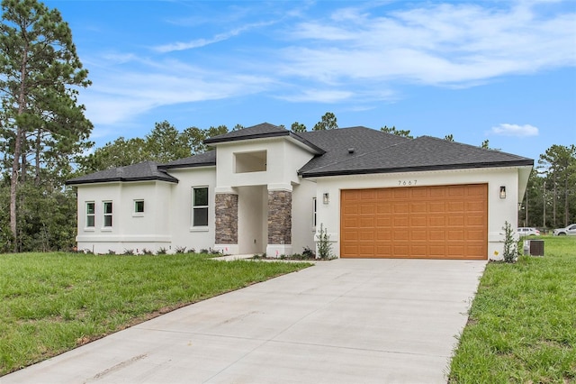 view of front of house featuring cooling unit, a garage, and a front yard