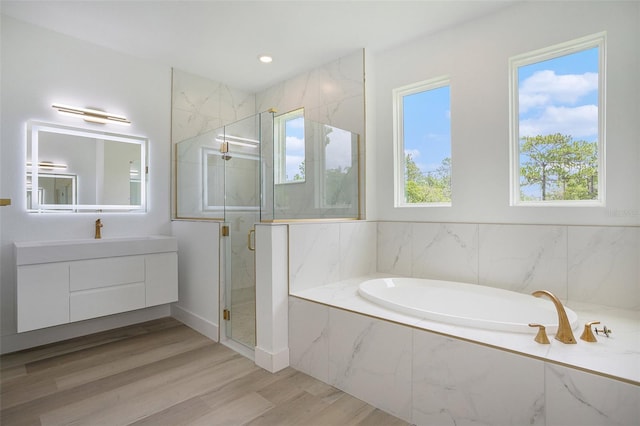 bathroom featuring vanity, hardwood / wood-style flooring, and separate shower and tub