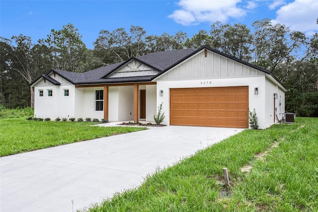 view of front of house featuring a garage, central AC, and a front yard