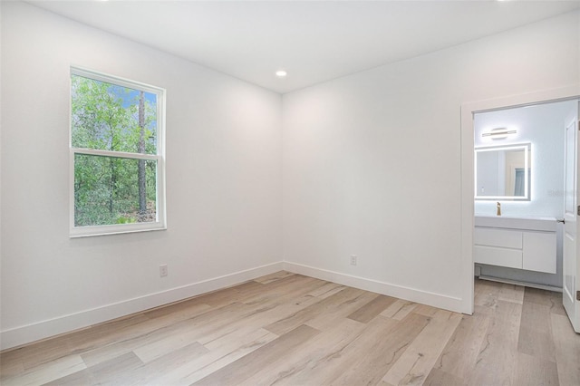 unfurnished bedroom with sink and light wood-type flooring