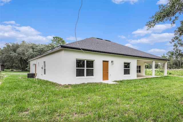 back of house with central AC unit and a lawn