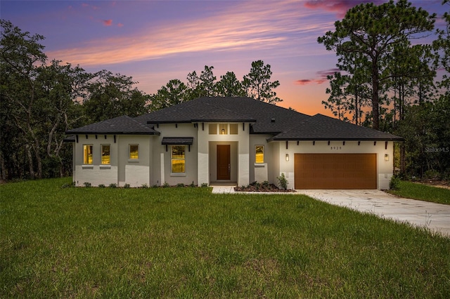 prairie-style house with a garage and a yard