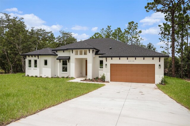 prairie-style house with a garage and a front lawn