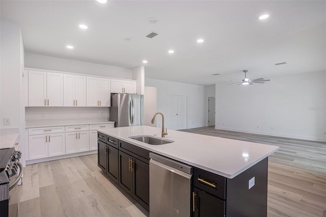 kitchen with sink, appliances with stainless steel finishes, light wood-type flooring, and ceiling fan