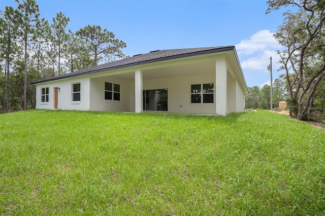 rear view of property with a lawn