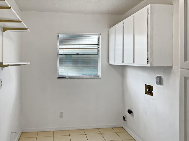 clothes washing area featuring light tile patterned flooring, cabinets, and hookup for a washing machine