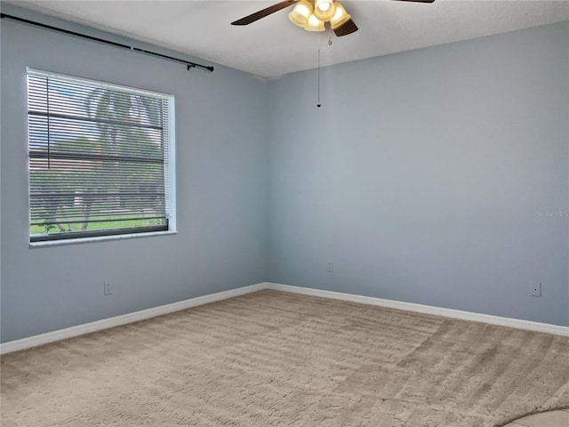 unfurnished room featuring a wealth of natural light, ceiling fan, and light carpet