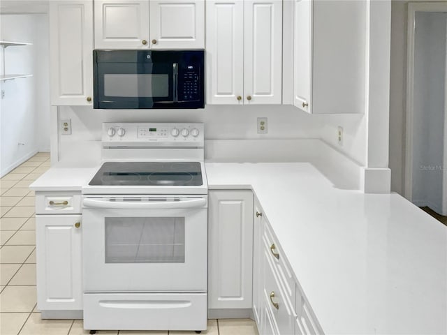 kitchen featuring white range with electric cooktop, light tile patterned flooring, and white cabinetry