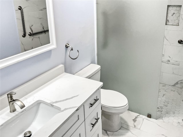 bathroom featuring vanity, toilet, and a tile shower