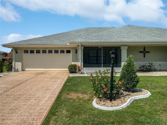 ranch-style home with a garage and a front lawn