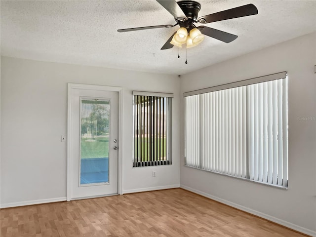 empty room featuring ceiling fan, light hardwood / wood-style floors, and a textured ceiling