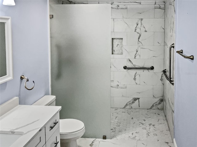 bathroom featuring a tile shower, vanity, and toilet