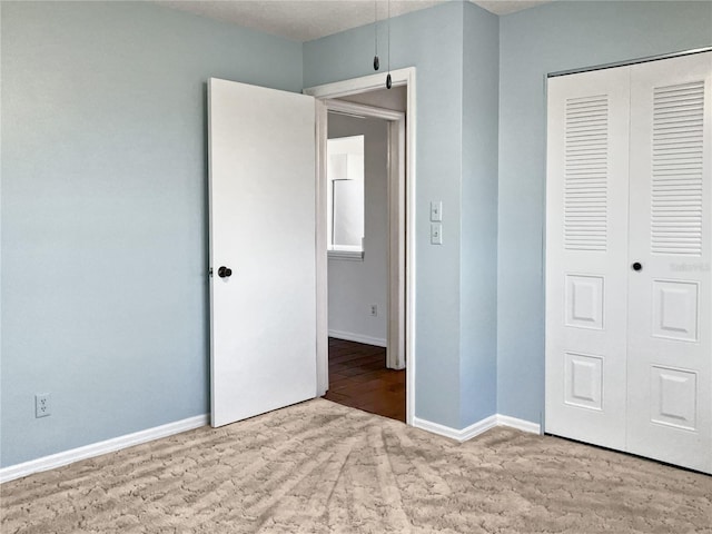 unfurnished bedroom with light wood-type flooring and a closet