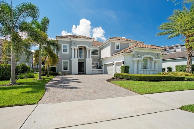 mediterranean / spanish-style home with a front lawn and a garage