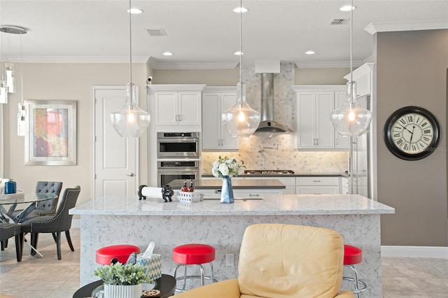 kitchen featuring decorative backsplash, ornamental molding, wall chimney exhaust hood, stainless steel appliances, and white cabinets