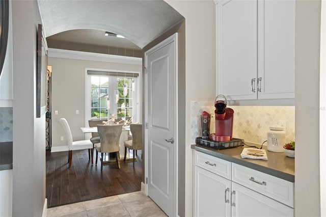 kitchen featuring decorative backsplash, white cabinetry, and light tile patterned floors