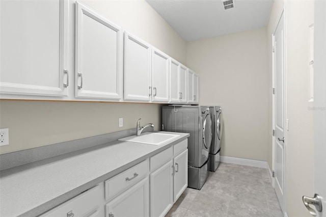 laundry area featuring washer and dryer, light tile patterned flooring, cabinets, and sink