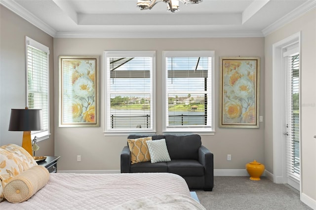 carpeted bedroom with a tray ceiling, crown molding, multiple windows, and a notable chandelier